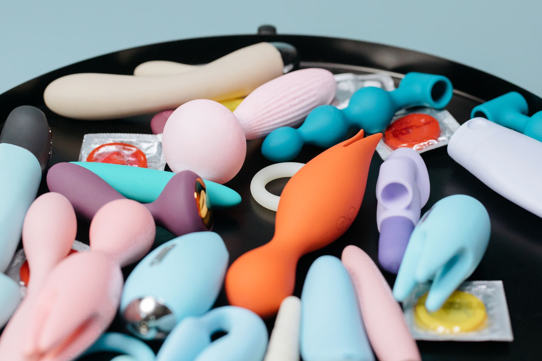 Hand holding a yellow vibrator against a purple backdrop, representing intentional self-care during recovery