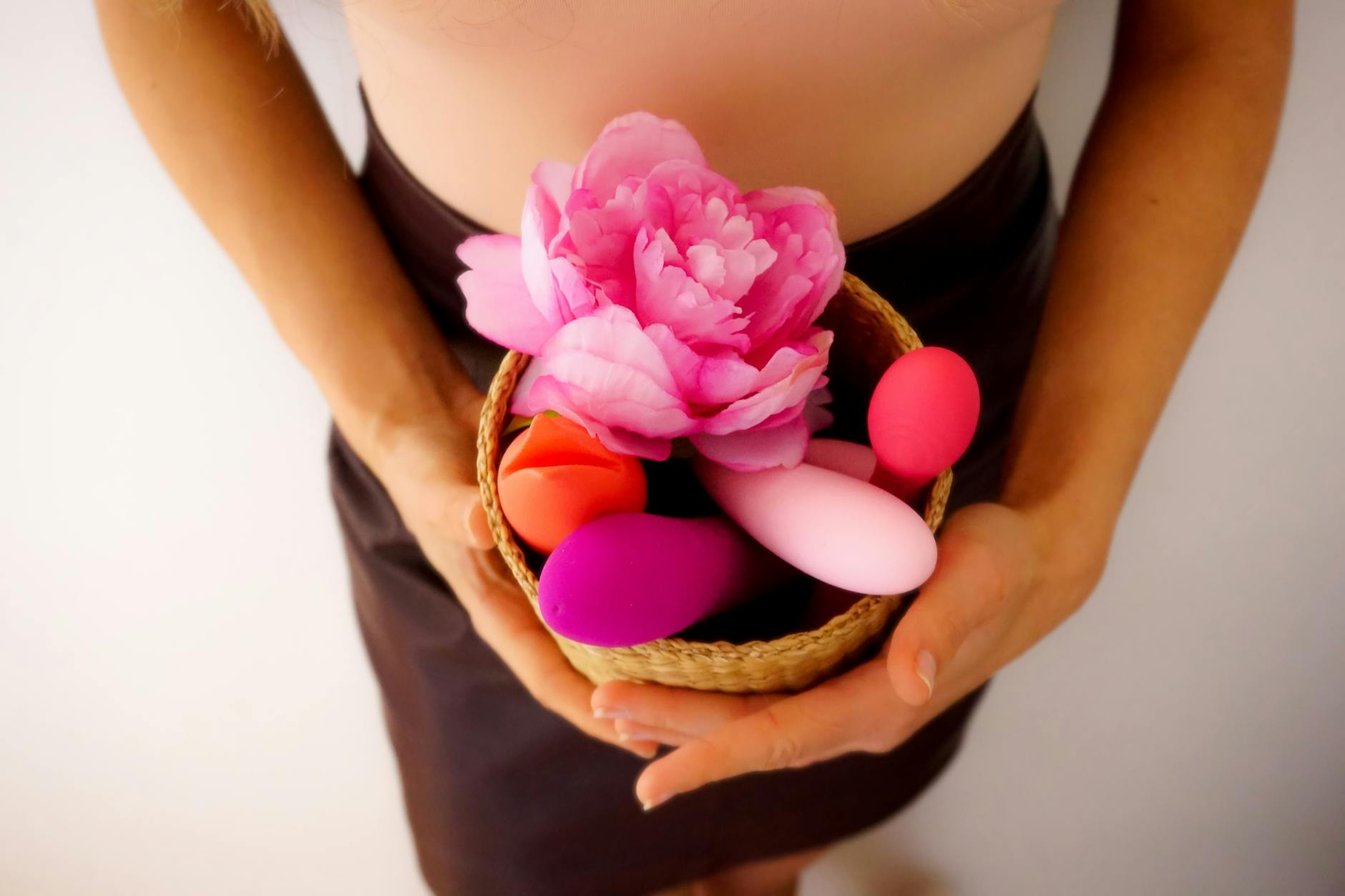 A vibrant arrangement of colorful lemon vibrators and pleasure toys in a basket with fresh flowers