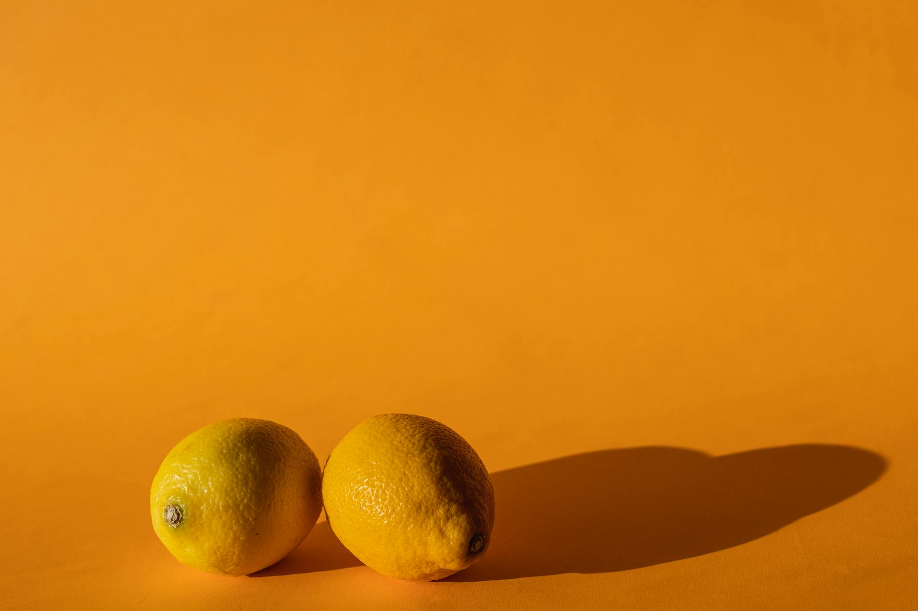 Ripe vivid lemons composed on a bright yellow background, symbolizing fresh sensuality and intentional pacing